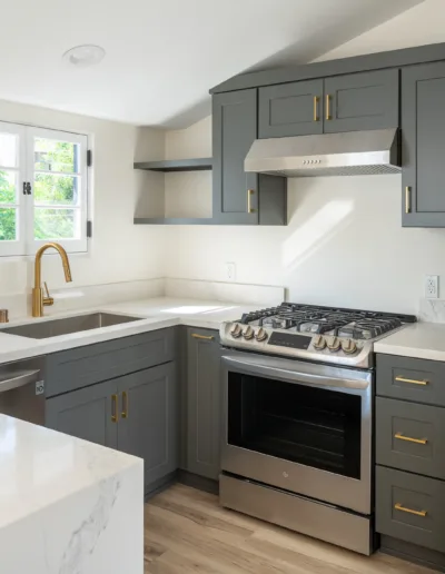 A kitchen with stainless steel appliances and gray cabinets.