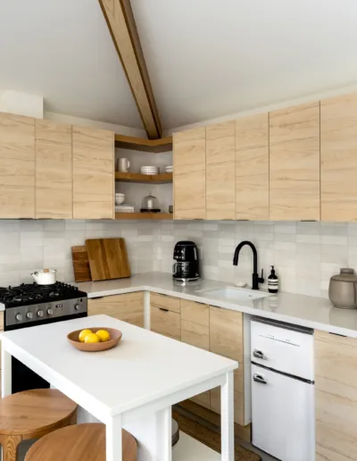 A small kitchen with white cabinets and a wooden island.
