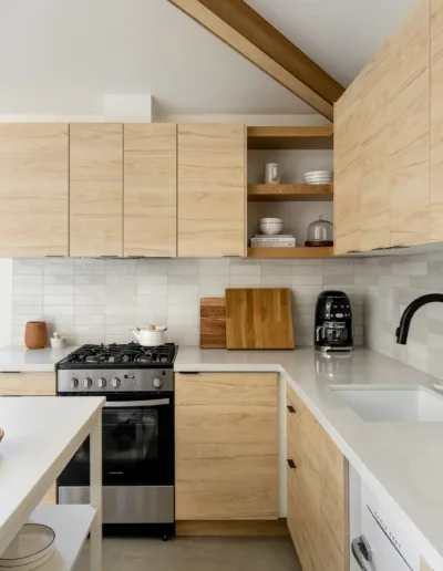 A modern kitchen with wooden cabinets and white counter tops.