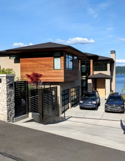A modern home with a wooden gate and a view of the water.
