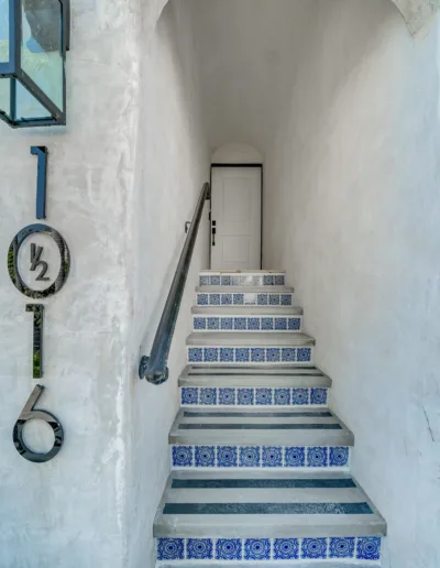 A staircase leading to a house with a blue tiled floor.