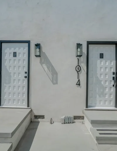 Two white doors on the side of a building.