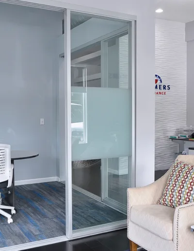An office with a glass door and chairs.