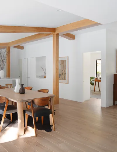 A kitchen and dining room with wooden beams.
