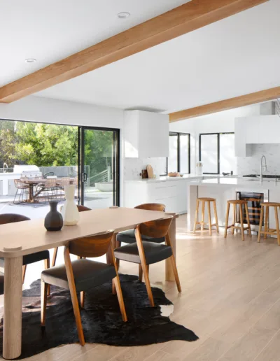 A modern kitchen and dining room with wooden beams.