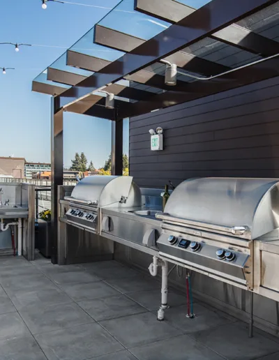 Bbq grills on a rooftop deck.